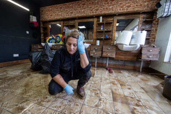 上周在科克郡米德尔顿的Urban Shave，一位心烦意乱的利亚·瓦兹正在清理，该店六个月前进行了翻新，现在被巴贝特风暴的洪水摧毁。图片：丹·莱恩汉